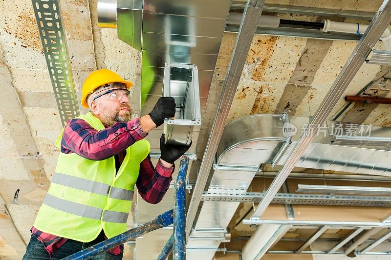 手工工人在建筑物内安装空调