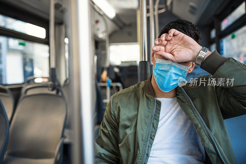 公交车上戴口罩的男子咳嗽，感觉2019冠状病毒病不舒服