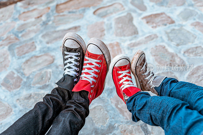 成人和儿童的脚穿一双不同颜色的帆布鞋