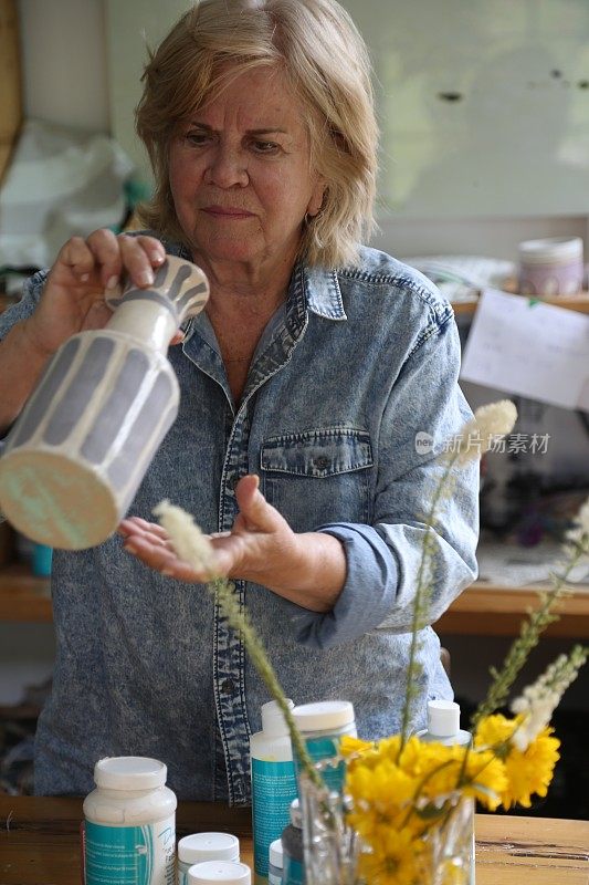 退休妇女在她的作坊里制作陶器