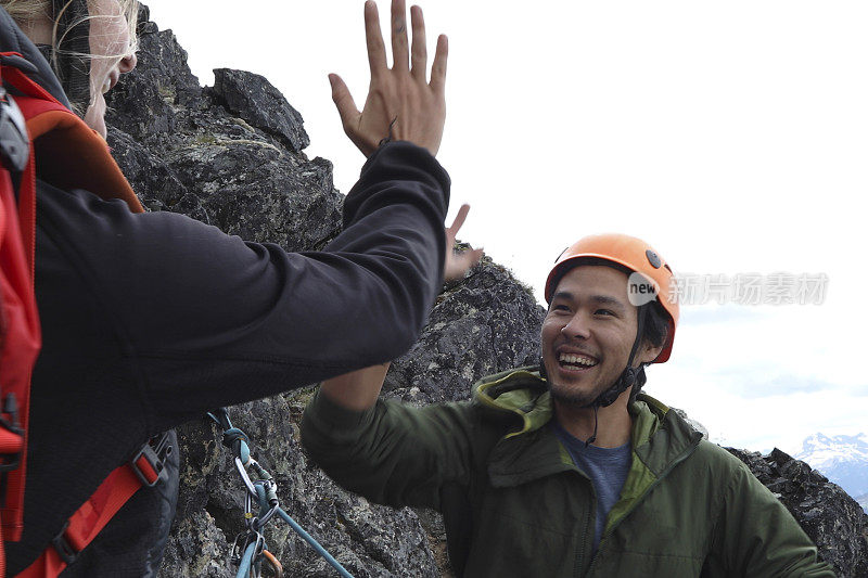 登山者朋友在山脊上击掌