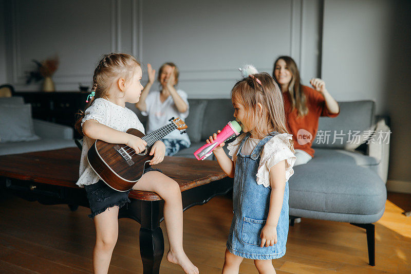 快乐的小女孩微笑着弹奏尤克里里在一个私人音乐学习课在家