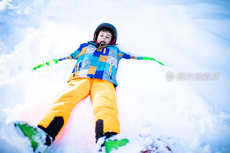 一个可爱的男孩做了一个雪天使