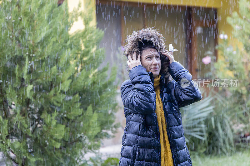 一个年轻女子在恶劣的天气里出去了。雨天。