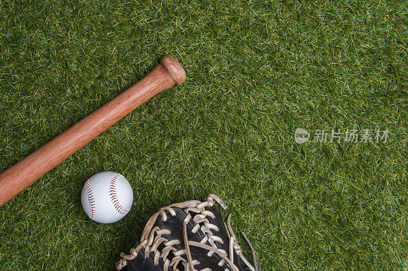 草地上的棒球棒、手套和球。体育主题背景与复制空间的文字和广告
