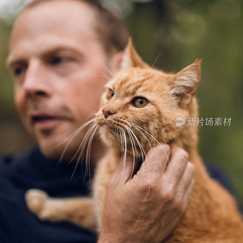 真正的男人在夏天和他的猫在户外