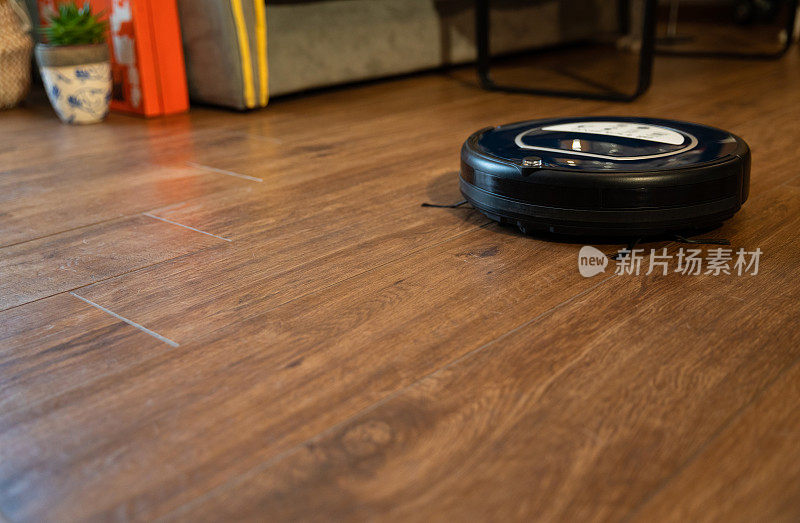 客厅强化木地板上的机器人真空吸尘器