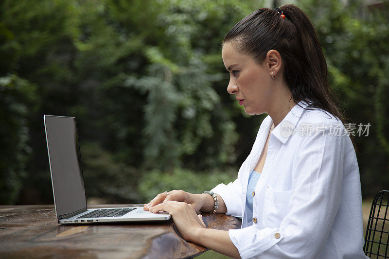 一名年轻女子正在用笔记本电脑工作