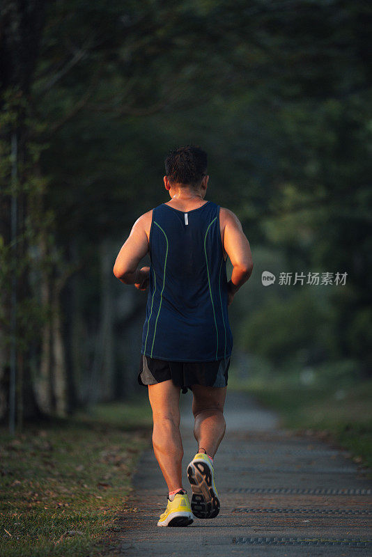 亚洲中年男子在公园跑步