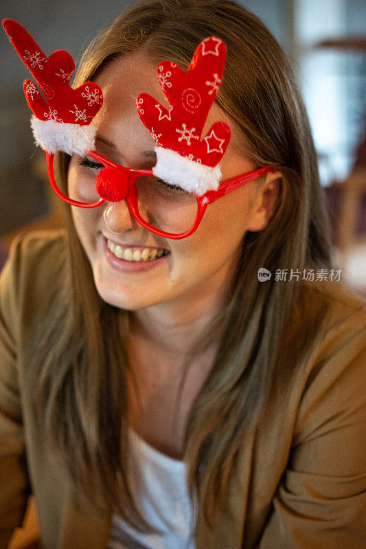 年轻漂亮的女商人戴着有趣的圣诞眼镜