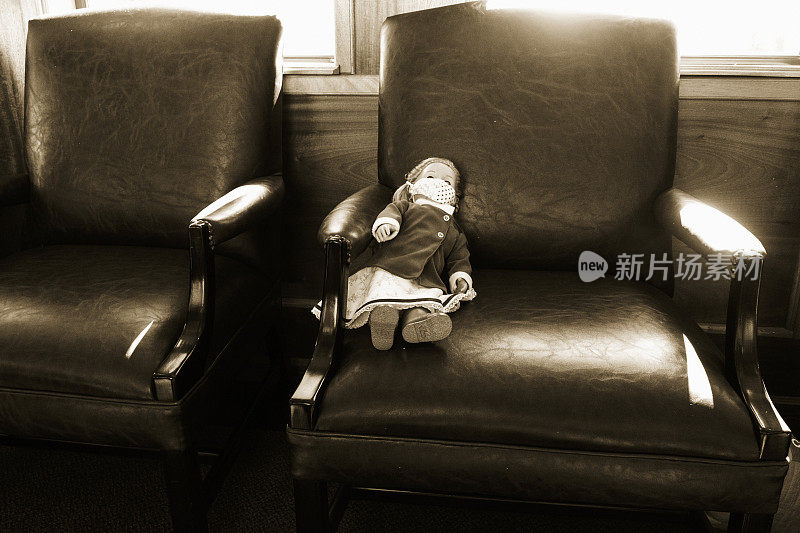 皮制座椅上的娃娃带着面具