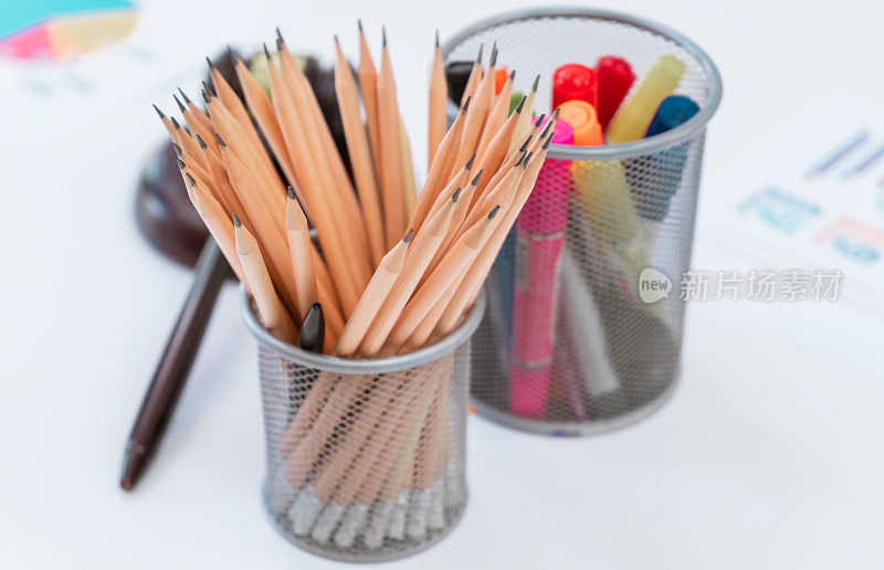 办公桌上放有彩色盘和铅笔的办公文具。