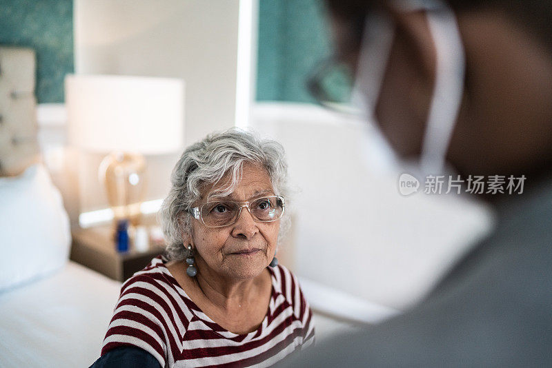 医生在卧室里和一位年长的女性聊天