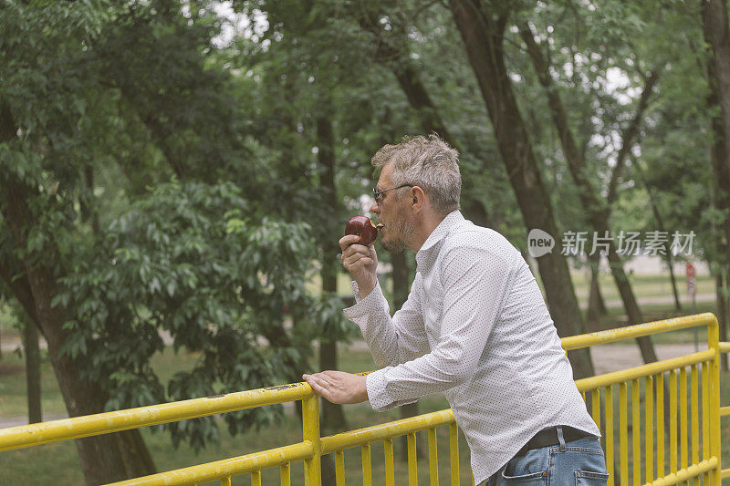 男子在户外吃苹果