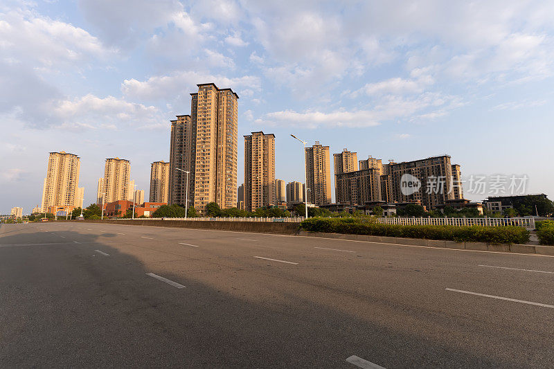 夕阳下空荡荡的柏油路和城市的天际线