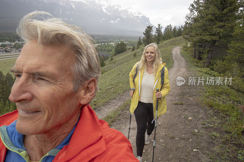 成熟的夫妇沿着山脊徒步旅行