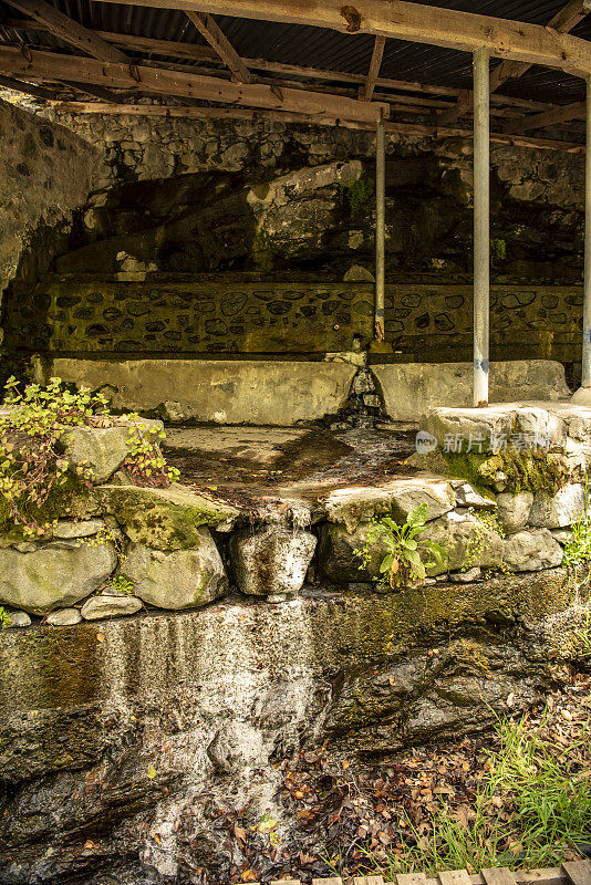 建在硫磺泉上的防护罩从石墙和水泥地面流出