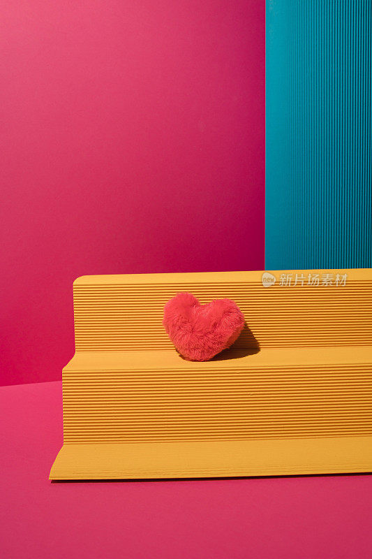 黄色的纸讲台与蓝色的专栏和粉红色的长毛绒心品红色的背景。最小限度的爱或情人的概念。