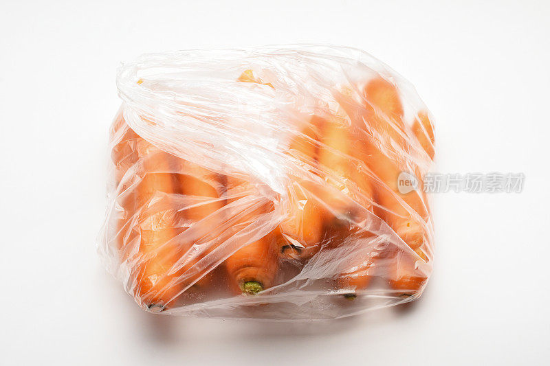 新鲜的胡萝卜放在塑料购物袋里
