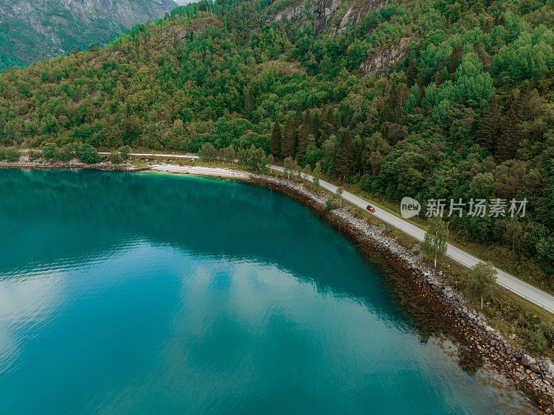 航拍的汽车在公路附近的湖在挪威日落