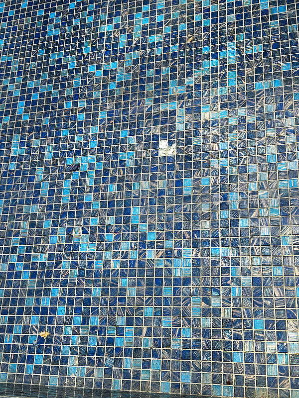 形象墙用蓝色方形马赛克瓷砖，小瓷砖之间用水泥填充，闪亮的装饰材料在浴室淋浴区