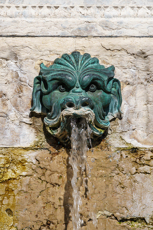古老的金属喷泉装饰的脸上有水从嘴里射出来