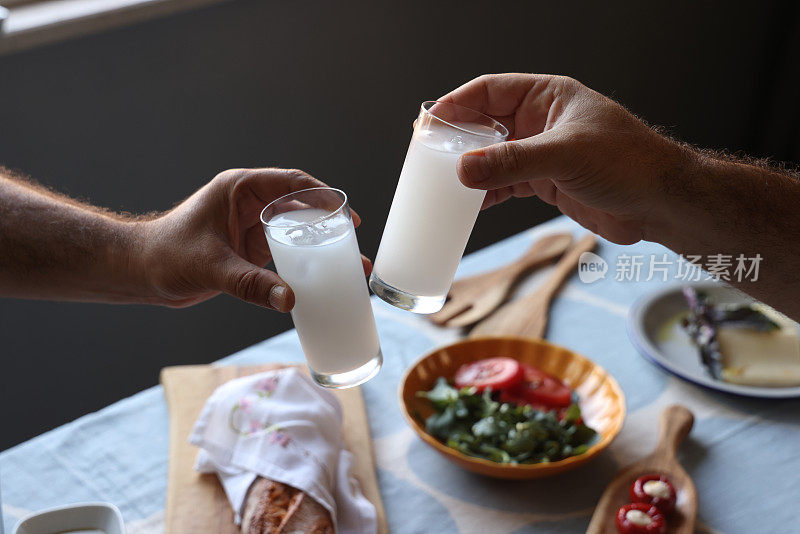 朋友们在美味的餐桌上喝着Raki或Ouzo