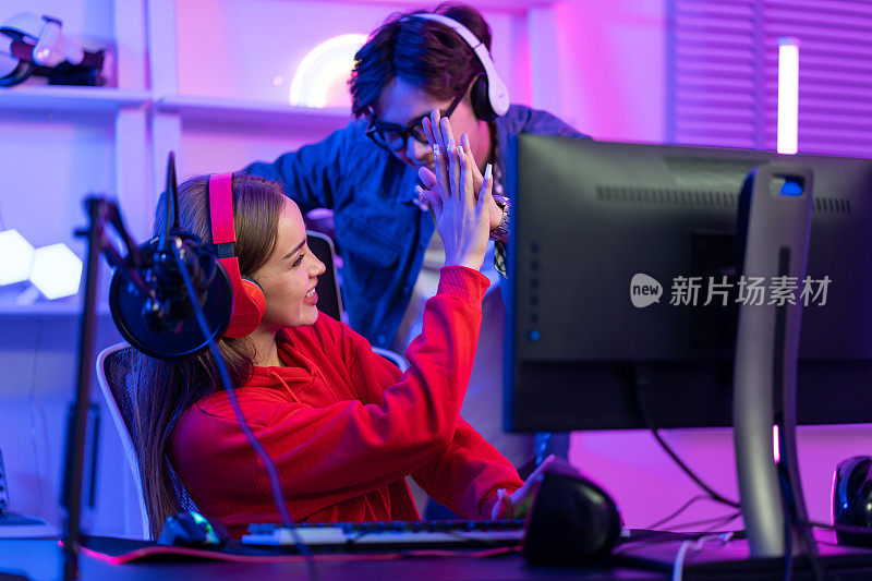 高加索战队的电子竞技玩家在电脑上玩在线视频游戏。有魅力的男女游戏玩家感到快乐，享受科技直播，同时在家里玩网络比赛