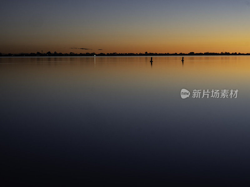 夕阳下湖面上的柱子剪影