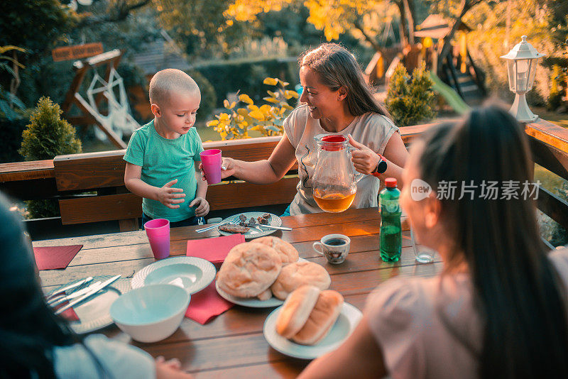 一家人在院子里烧烤，在餐桌上吃饭