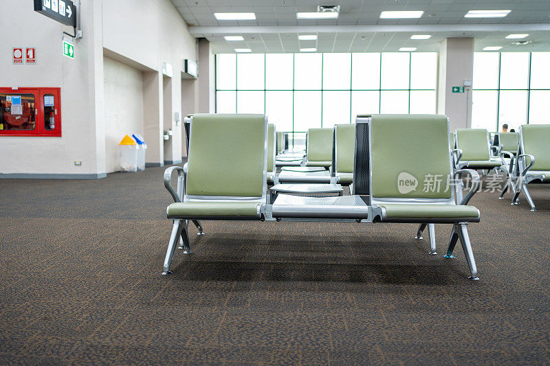 机场候机楼的绿色椅子。机场候机区空座。