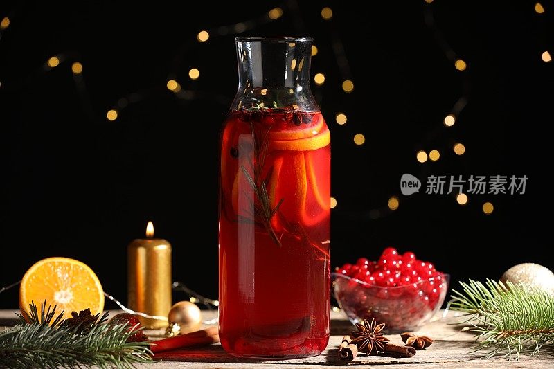 玻璃瓶子芳香的潘趣饮料，原料和圣诞装饰在木制桌子上