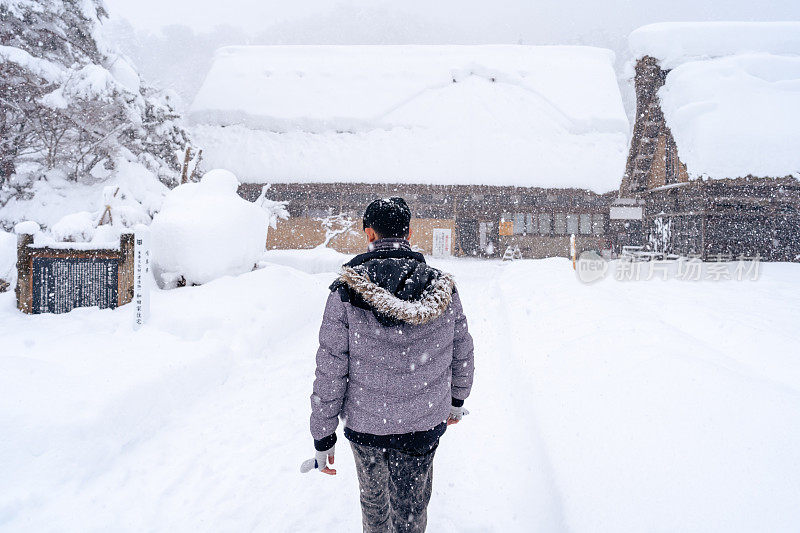 日本冬季，许多游客在白川古村享受一日游，那里有厚厚的积雪