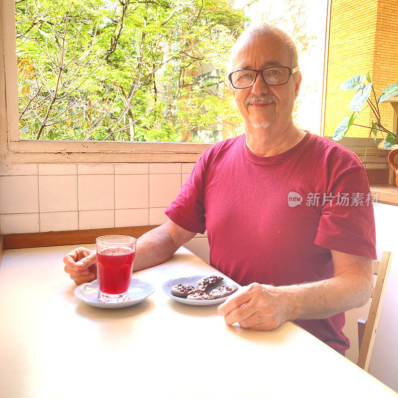 第三个男人在家里的厨房里拿着零食