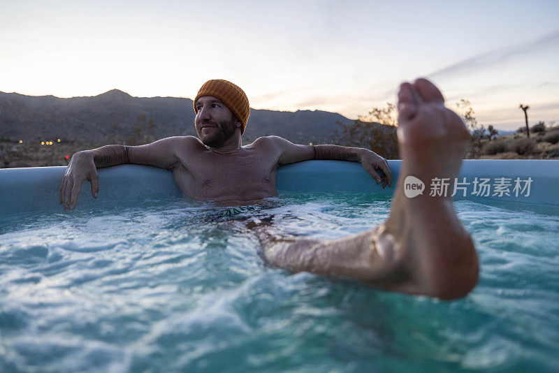 黄昏的宁静:一个男人的宁静浸泡在户外按摩浴缸心爱的风景