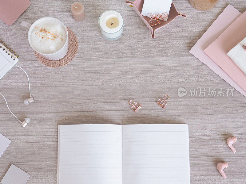 一张女性化的柔软办公桌的俯视图，基于浅木纹和粉色米色，一个女性化的工作空间的形象。