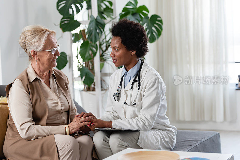 专科医生在诊所给病人咨询。一位女医生正在和一位老年女病人谈话。