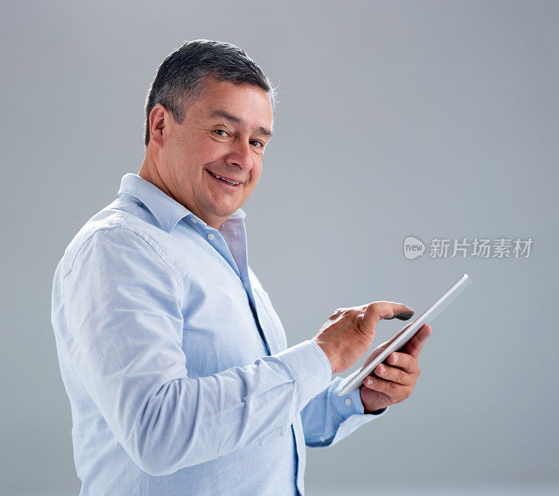 成年男子微笑着在平板电脑上使用应用程序