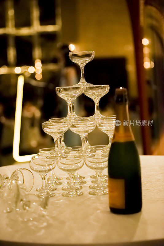 一瓶香槟和用玻璃做成的金字塔