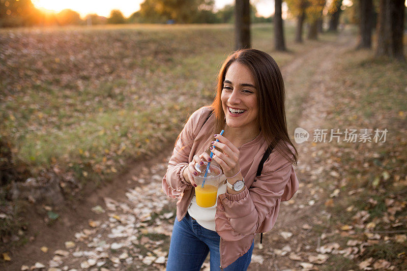 快乐，喝果汁，在秋天的公园里散步