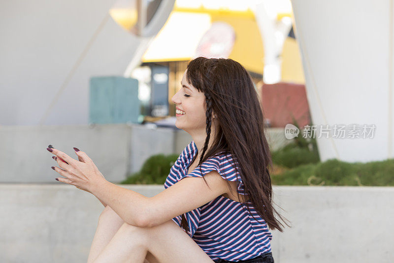年轻女子在城市公园使用手机