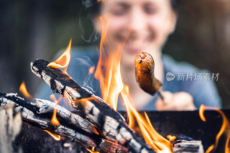 在户外野餐。在烧烤架上烤香肠