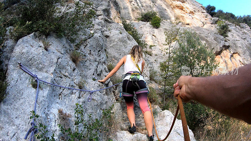 女人爬陡峭的岩石路线