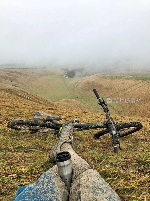 山地车和山地车在山上喝着烧瓶里的咖啡