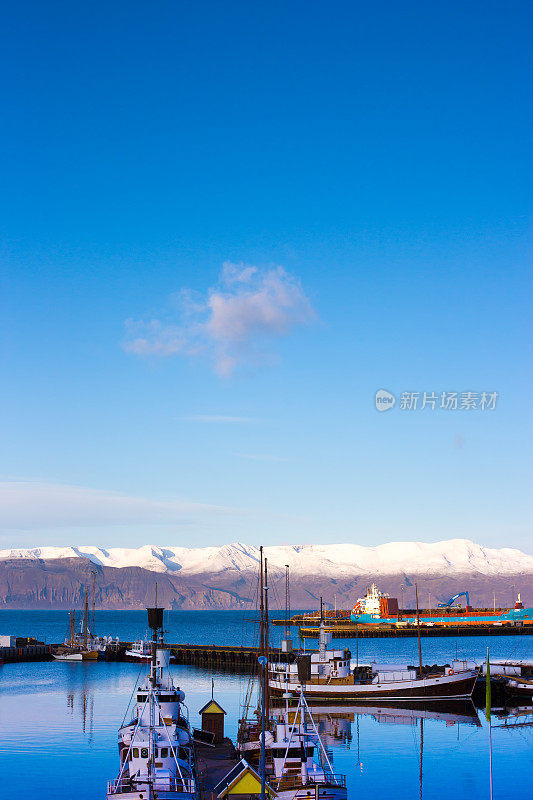 Húsavík，冰岛:清晨阳光明媚的港口里的小船