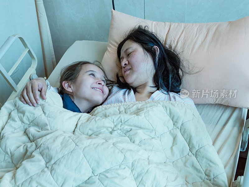 母亲和女儿一起躺在医院的病床上