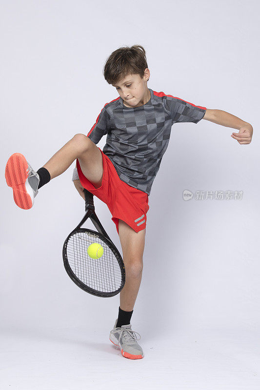 男孩在白色背景上打网球