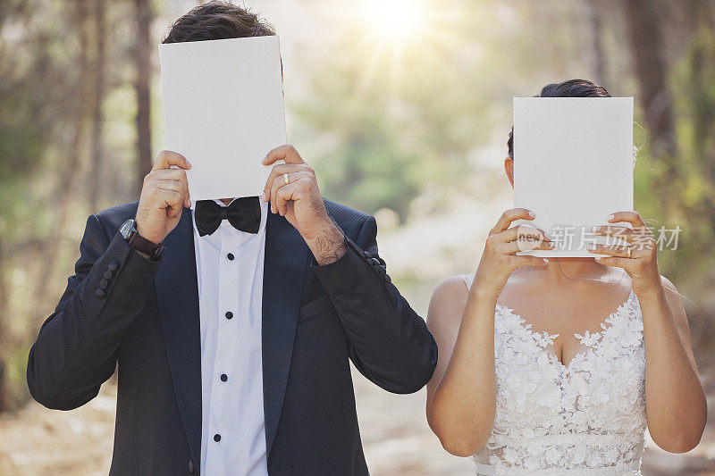 新婚夫妇用白纸遮住脸。