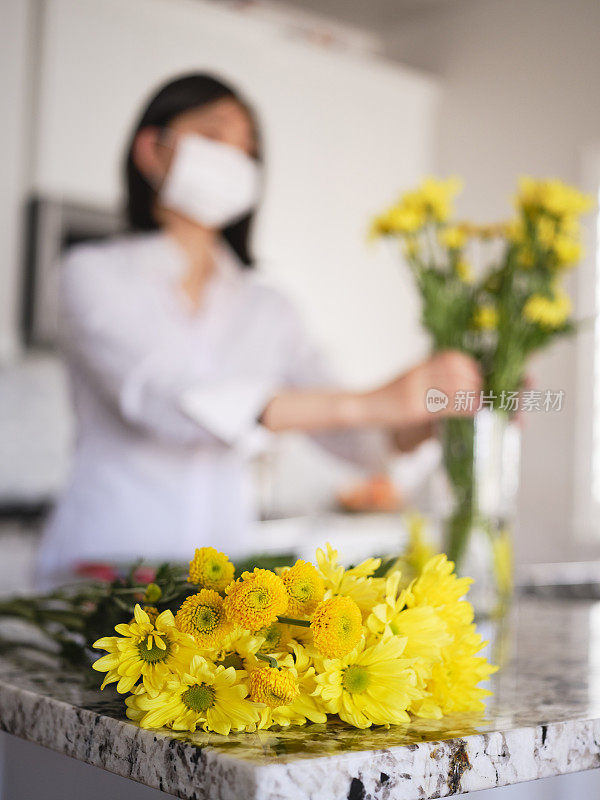 亚洲妇女在她的家里插花