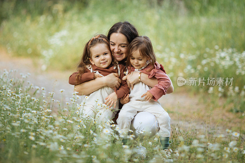 快乐的妈妈和采摘鲜花的小女孩们